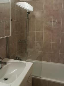 y baño con ducha, bañera y lavamanos. en Wisteria House - Holiday Apartment, en Cadenazzo