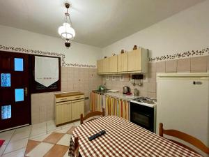 a kitchen with a table and a white refrigerator at Apartments Dražica 4 in Zubovići