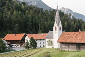 a white church with a mountain in the background at Gasthof Kronburg in Zams