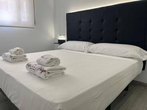 a white bed with towels on top of it at H Pelayo Auto Check-In Rooms in Noja