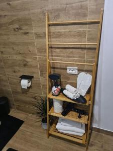 estante de madera en el baño con toallas en The Green House en Timisoara