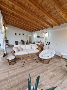 una sala de estar con un sofá blanco y mesas. en The Green House en Timişoara