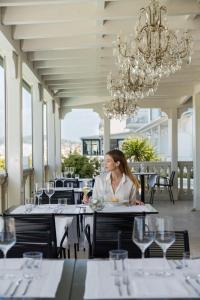 una mujer sentada en una mesa en un restaurante en Hotel Carducci 76, en Cattolica