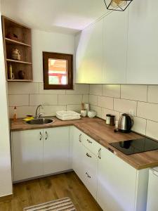 a kitchen with white cabinets and a sink at Farmstead Green Haven in Mojkovac