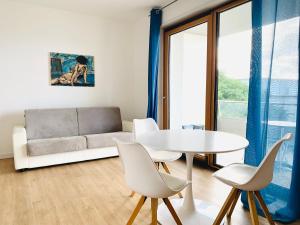 sala de estar con sofá, mesa y sillas en Le Conchiglie Residence, en Porto Torres