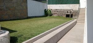 a garden with a retaining wall and a lawn at Vista a las Cíes in Moaña