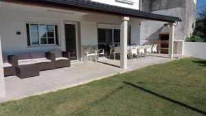 a patio with chairs and a couch and a table at Vista a las Cíes in Moaña