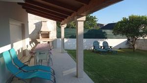 a patio with chairs and a table and a grill at Vista a las Cíes in Moaña +46 photos