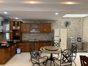 eine Küche mit einem Tisch und einem Kühlschrank in der Unterkunft Luxury House with 3 bedrooms & balcony-terrace in Ho-Chi-Minh-Stadt