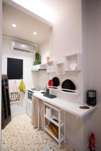 a kitchen with white shelves and a white counter at Laonikos Seaside Urban Studio SKG in Thessaloniki
