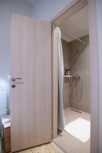 a bathroom with a shower with a glass door at Laonikos Seaside Urban Studio SKG in Thessaloniki