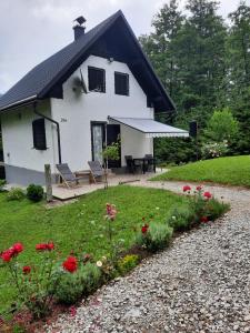 a white house with a black roof and a garden at Holiday Home Raušel in Turke
