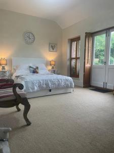 a bedroom with a bed and a clock on the wall at The Jasmine Suite in Newark upon Trent