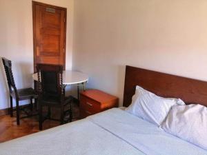 a bedroom with a bed and a table and chairs at Sasimi Nice Hostel in Braga