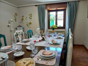 una mesa de comedor con platos y vasos. en Casa Albaitar Jardin privado exclusivo clientes en Azcona