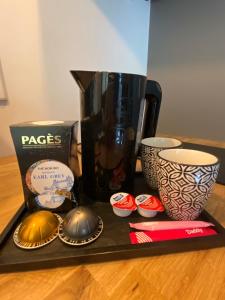 un vassoio con una caffettiera e tazze sul tavolo di La petite maison du Thabor a Rennes