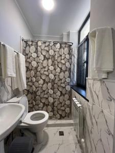 La salle de bains est pourvue de toilettes et d'un mur en pierre. dans l'établissement Premium 777 Yunusabad, à Tachkent