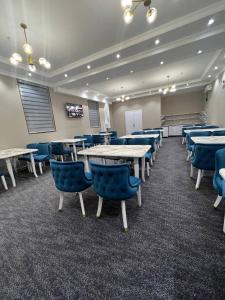 une salle de conférence avec des tables et des chaises bleues dans l'établissement Premium 777 Yunusabad, à Tachkent