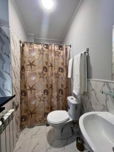 La salle de bains est pourvue de toilettes et d'un rideau de douche. dans l'établissement Premium 777 Yunusabad, à Tachkent