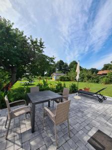 a patio with a black table and chairs and a lawn at Ferienhuette in Altfriesack