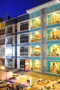 an apartment building with a parking lot in front of it at Pimrada Hotel in Patong Beach