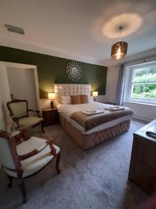 een slaapkamer met een groot bed en een stoel bij Fairwater Head in Axminster