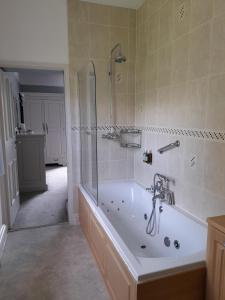 a bathroom with a bath tub and a shower at Fairwater Head in Axminster