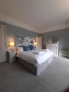 a bedroom with a large white bed with blue pillows at Fairwater Head in Axminster