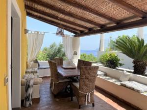 jadalnia ze stołem i krzesłami na patio w obiekcie La Casa sul Porto di Santa Marina - Isole Eolie w mieście Santa Marina Salina