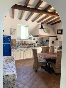 kuchnia ze stołem i krzesłami oraz kuchnia z blatem w obiekcie La Casa sul Porto di Santa Marina - Isole Eolie w mieście Santa Marina Salina