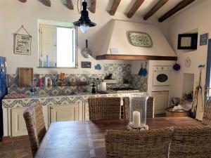 cocina con mesa, sillas y barra en La Casa sul Porto di Santa Marina - Isole Eolie, en Santa Marina Salina