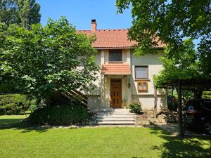 a white house with a brown door and a yard at Szilvás 10 in Szigliget