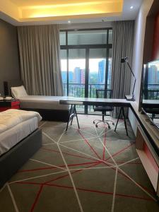 a hotel room with a bed and a desk and a television at Studio Bedroom with Balcony in Kuala Lumpur