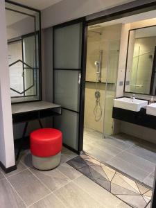 a bathroom with a red stool and a sink at Studio Bedroom with Balcony in Kuala Lumpur