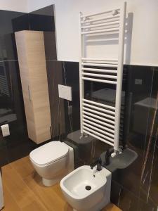 a bathroom with a white toilet and a sink at La Casa de Papel - Self Check in, Smart Tv, tutti i confort, appartamento privato non condiviso in Cavarzere +8 photos