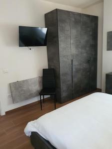 um quarto com uma cama e uma televisão na parede em La Casa de Papel - Berlino - Self Check in, Smart Tv, tutti i confort, nuova costruzione em Cavarzere