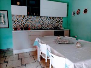 una cucina con tavolo bianco e armadietti bianchi di Casa vacanza zia Ersilia a Rotondi