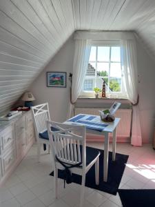 a dining room with a table and chairs and a window at Mowennest Morsum in Morsum