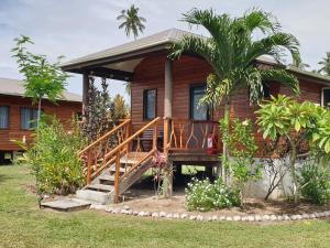 a wooden house with a staircase in front of it at Nabuco Estate Bure Rentals in Naweni