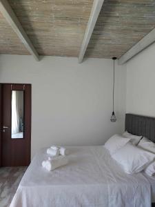 um quarto com uma cama branca e um tecto de madeira em Valia's Beach House em Samos