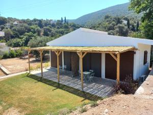 Blick auf ein Haus mit einer hölzernen Pergola in der Unterkunft Valia's Beach House in Samos