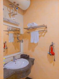 een badkamer met een wastafel, een spiegel en handdoeken bij A25 Hotel - Dịch Vọng Hậu in Hanoi