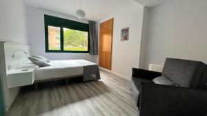 a bedroom with a bed and a chair and a window at Casa Santa Elena in Santa Cristina d'Aro