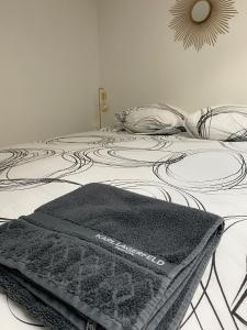 un letto bianco e nero con una coperta sopra di La petite maison du Thabor a Rennes Altre 6 foto