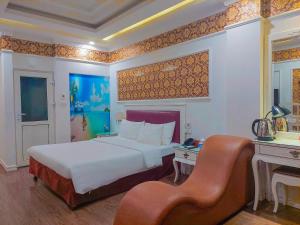 een slaapkamer met een bed en een bureau met een stoel bij A25 Hotel - Dịch Vọng Hậu in Hanoi