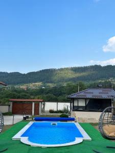 a swimming pool in front of a house at Villa Paradise in Beli Iskar