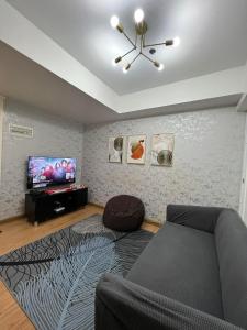 a living room with a couch and a flat screen tv at Azure Staycation Beach View 2br in Manila