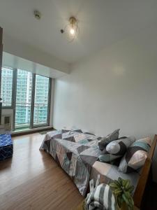 a bedroom with a bed and a large window at Azure Staycation Beach View 2br in Manila