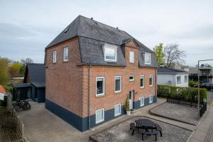 een groot gebouw van rode baksteen met een zwart dak bij Newly renovated 1-Bed Apartment in Aalborg in Aalborg