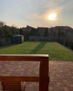 un banco en un patio con la puesta de sol en el fondo en Charming individual house with a beautiful garden and self checkin en Satu Mare